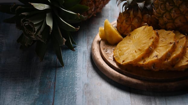 Close up fresh sliced pineapple on wooden background. Top view, tropical fruits, summer concept.