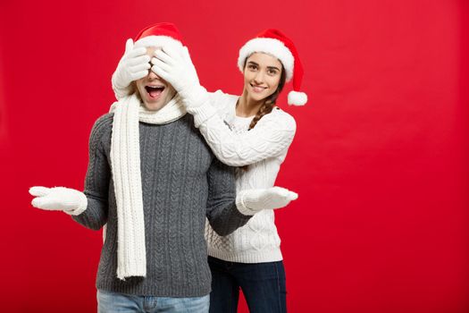 Christmas Concept - portrait lovely girlfriend surprising close her boyfriend eyes in Christmas day.