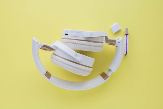 Wireless headphones isolated on a yellow background
