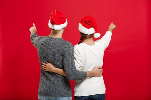 Christmas Concept - back view of portrait lovely young couple finger on side well use for presentation or montage.