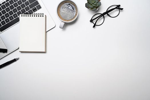 Simple workplace with laptop computer, coffee cup, glasses and notebook. Top view, flat lay, copy space.