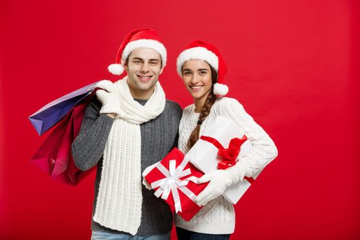 Christmas Concept - Young attractive couple holding shopping bag enjoy shopping and celebrating in Christmas day.