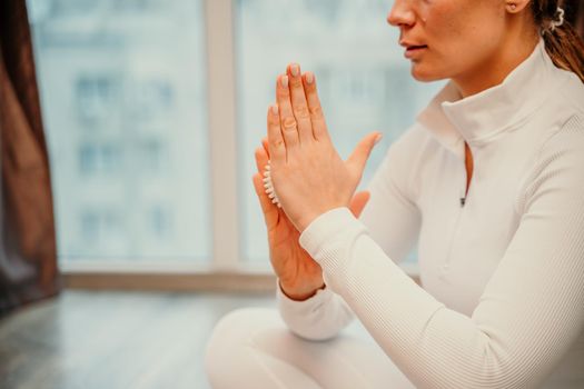 Athletic slim caucasian woman doing thigh self-massage with a massage ball indoors. Self-isolating massage.