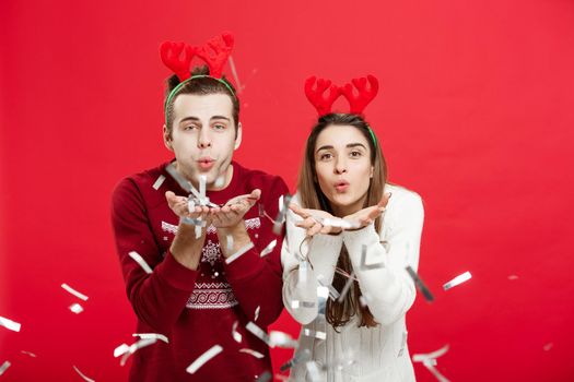 Christmas Concept - Happy caucasian man and woman in reindeer hats celebrating christmas toasting with champagne flutes, congratulating on xmas.