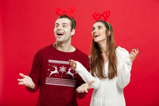 Christmas Concept - Romantic couple in a christmas sweaters waiting for snow.