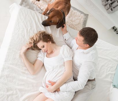 top view. a married couple with a pet in the bedroom in the morning. the concept of parenthood