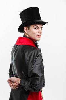 Vampire Halloween Concept - Portrait of back view handsome caucasian Vampire in black and red halloween costume isolated on white.
