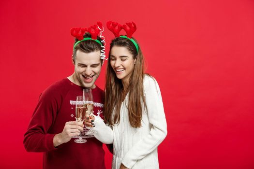 Christmas concept - Happy young couple in sweaters celebrating christmas with Champagne.