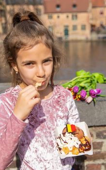 Belgian waffles are eaten by children on the street. Selective focus. Food.