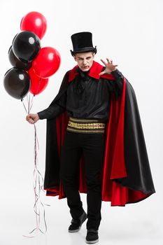 Vampire Halloween Concept - Full-lenght Portrait of handsome caucasian Vampire in black and red halloween costume.