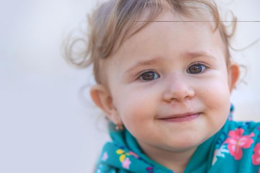 Baby plays snot in the street with a cold nose. Selective focus. Child.