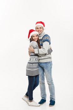 Christmas concept - Full-length Young attractive caucasian couple giving a hug celebrating for Christmas day