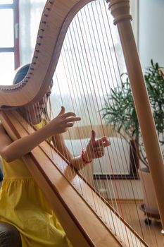 The child plays the harp. Selective focus. Kid.