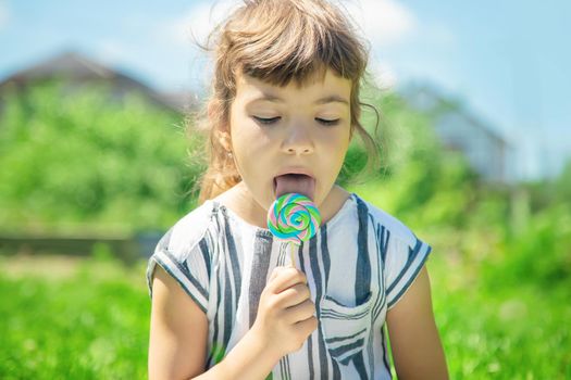 child eats lollipop on nature. Selective focus.