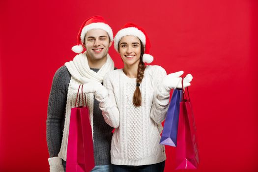 Christmas Concept - Young attractive couple holding shopping bag enjoy shopping and celebrating in Christmas day.