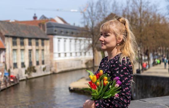 Bruges Belgium - April 23, 2022 girl with flowers. Selective focus. Nature.