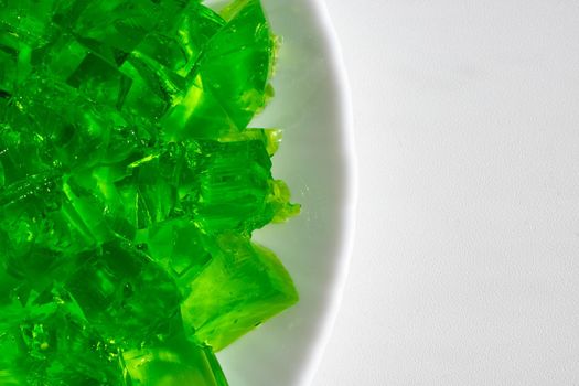 Delicious green jelly cube on white background.