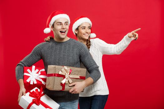 Christmas Concept - Young attractive couple holding a lot of presents enjoy shopping and celebrating in Christmas day.