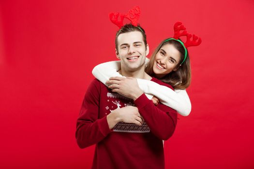 Christmas Concept - Romantic couple in a christmas sweaters huging each other.
