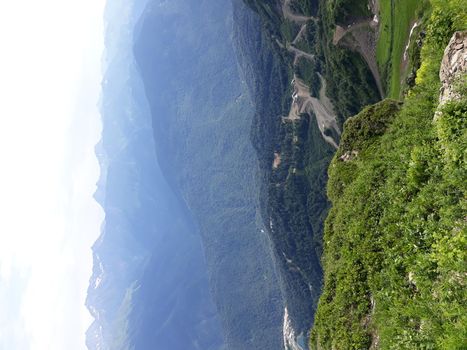 Panoramic mountain landscape with valleys and forested mountain peaks.