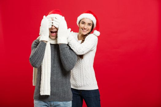 Christmas Concept - portrait lovely girlfriend surprising close her boyfriend eyes in Christmas day.