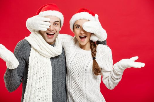 Christmas Concept - Young happy stylish couple in winter clothes close eyes each others celebrating in Christmas day.