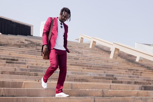 black businessman walking down a city staircase with his briefcase, concept of business and city lifestyle, copy space for text