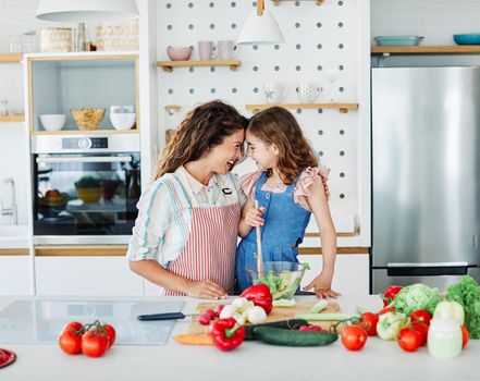 Daughter and mother preparing food in the kitchen