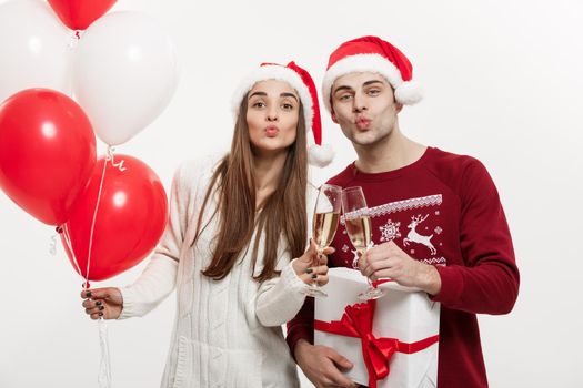 Christmas Concept - Young girlfriend holding balloon and champagne playing and celebrating with her boyfriend on Christmas day.