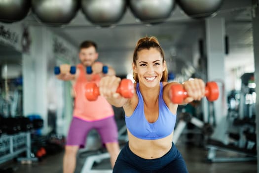 Happy healthy fit people at the gym exercising