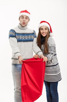 Chirstmas concept - young attractive couple with Santa red bag celebrating Chirstmas day. Isolated on White background.
