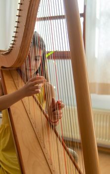 The child plays the harp. Selective focus. Kid.