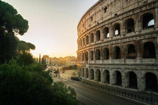 Rome Colosseum at morning sunrise and crowded street of Rome , Italy . The Colosseum was built in the time of Ancient Rome in the city center. It is one of most popular tourist attractions in Italy .