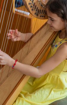 The child plays the harp. Selective focus. Kid.