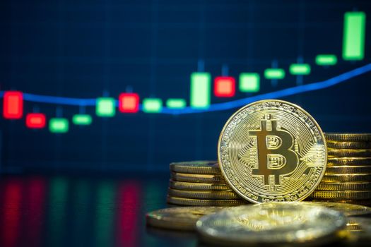 Bitcoin and cryptocurrency trading system concept - Image of Physical bitcoin pile against market price chart as blur background.