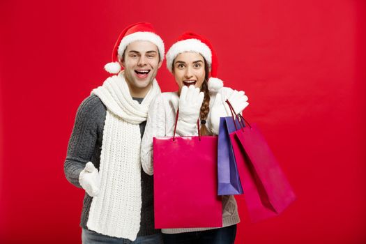 Christmas Concept - Young attractive couple holding shopping bag enjoy shopping and celebrating in Christmas day.