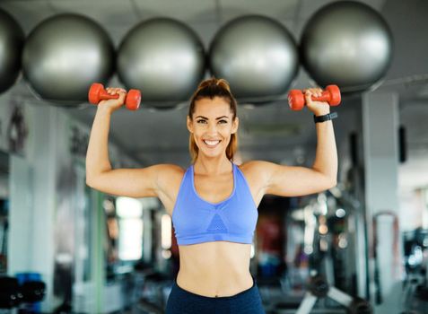 Happy healthy fit people at the gym exercising