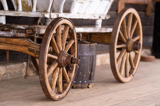old wooden wheels are on the carriage at the ranch.
