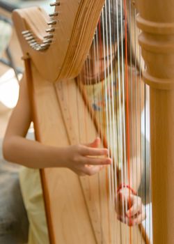 The child plays the harp. Selective focus. Kid.