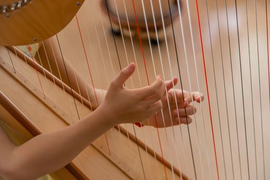 The child plays the harp. Selective focus. Kid.