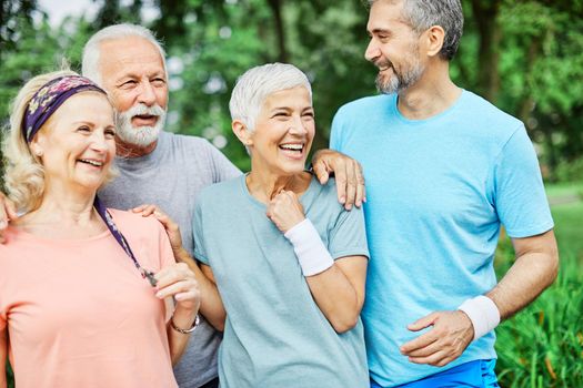 Smiling active senior people posing together in the park