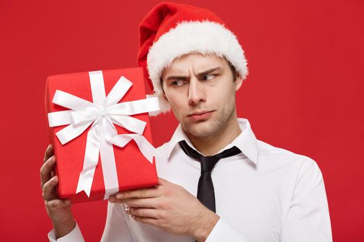 Christmas Concept - portrait close-up Santa christmas businessman over red background holding red gift.