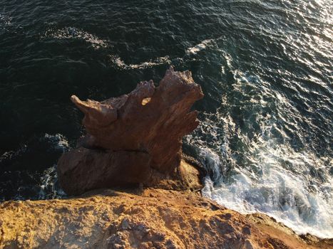 The rock or lava formation with the shape of a large animal or dragon head arise from the water. Popular travel destination volcanic rock formation in the shape of a dragon's head. Crimea, Fiolent