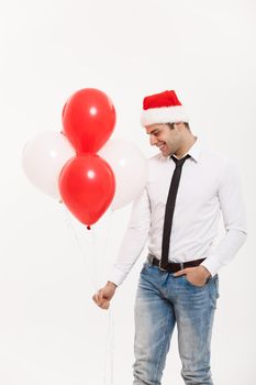 Christmas Concept - Handsome happy Business man walking with red balloon celebrate merry christmas and happy new year wear santa hat.