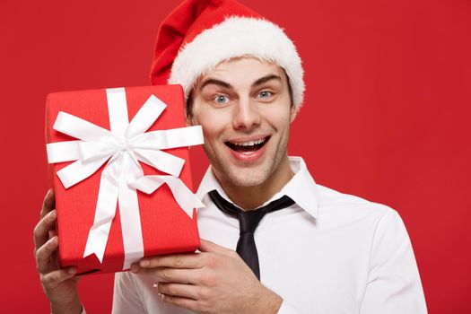 Christmas Concept - portrait close-up Santa christmas businessman over red background holding red gift.