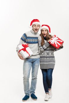 Christmas Concept - Young adorable couple holding presents isolated on white grey background