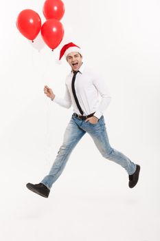 Christmas Concept - Handsome Business man jumping for celebrating merry christmas and happy new year wear santa hat with red balloon.