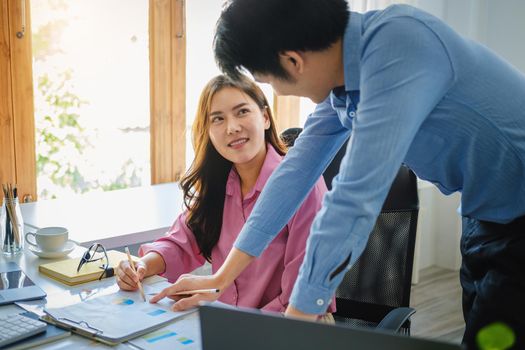 negotiation, analysis, discussion,asian male economist pointing out a document explaining the investment finance program to the company owner to plan marketing and hedging business risks