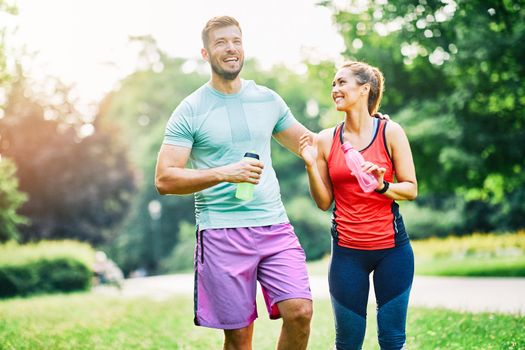 Portrait of a young couple exercising in a park outdoors