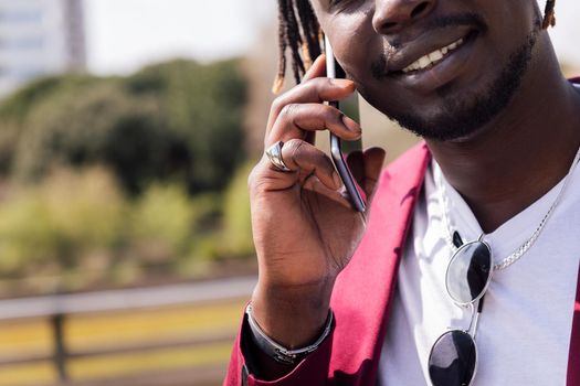 unrecognizable black businessman talking on a smart phone outdoors, concept of technology and communication, copy space for text
